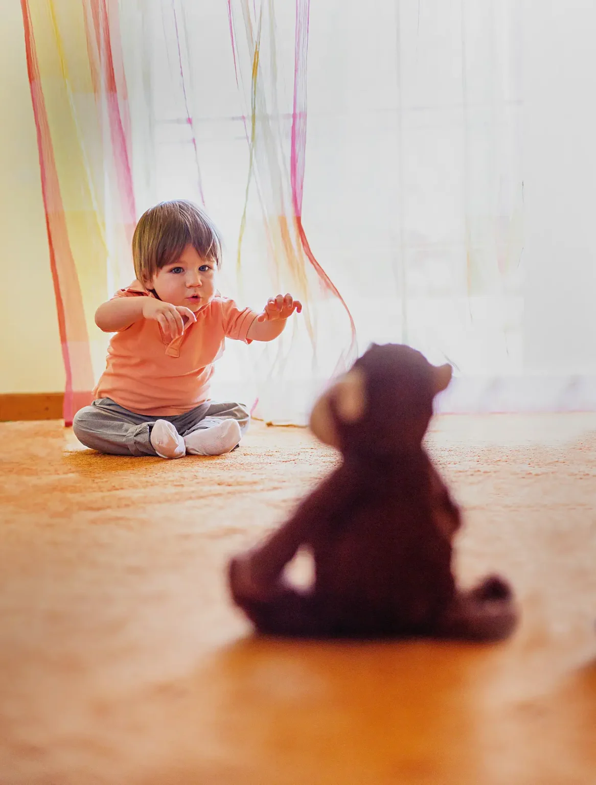 a child sitting on the floor with a stuffed animal