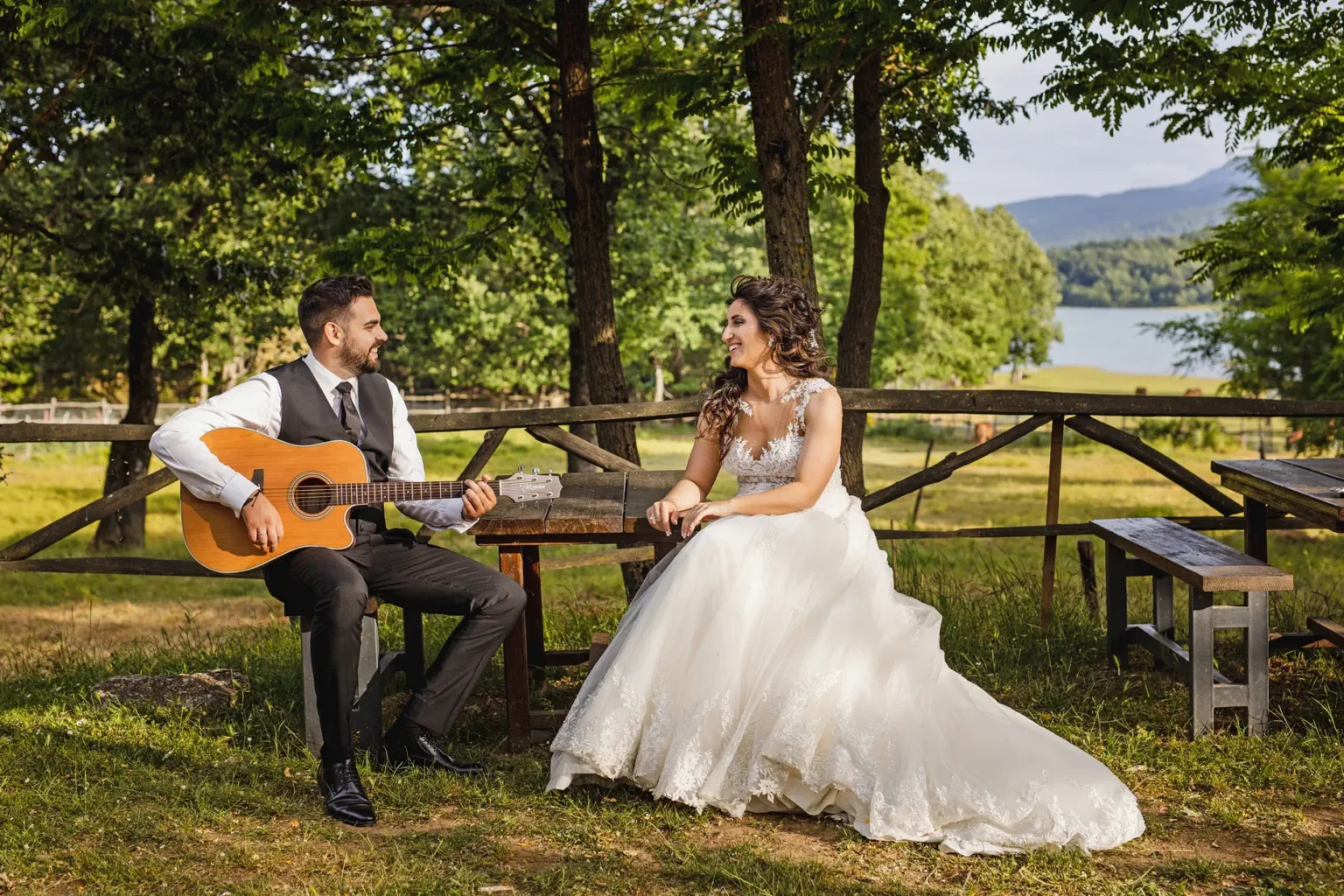 a man playing a guitar and a woman sitting on a bench