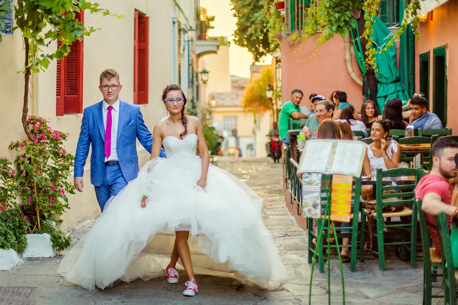 a man and woman in a wedding dress walking down a street