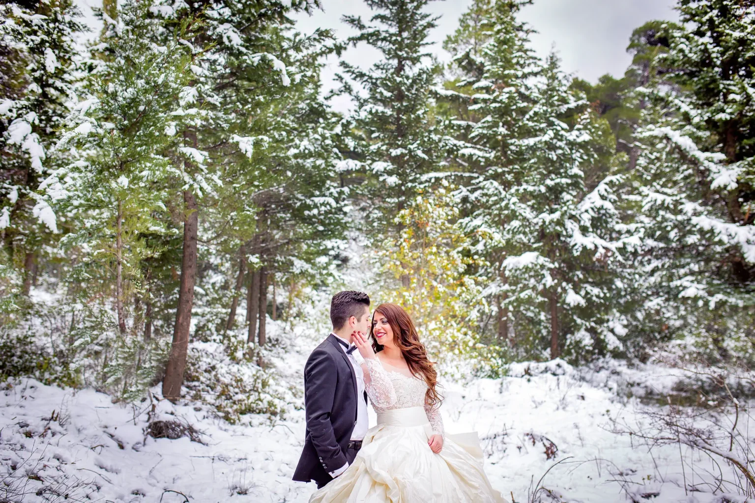 a man and woman in a snowy forest
