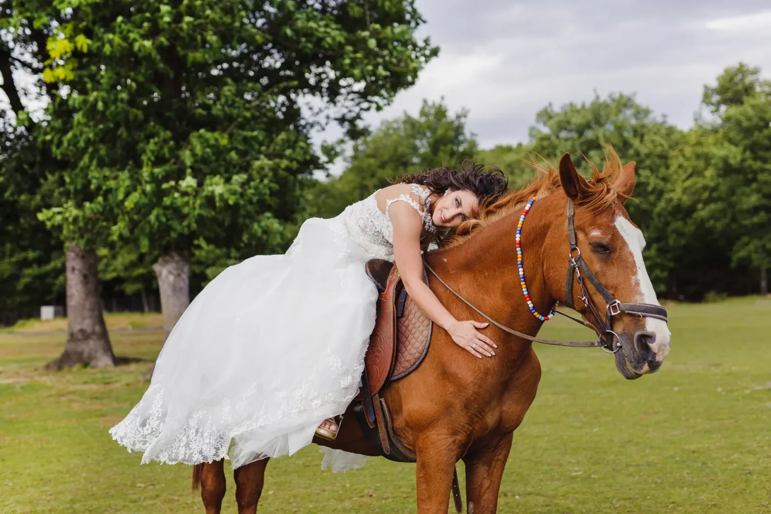 a woman in a white dress riding a horse