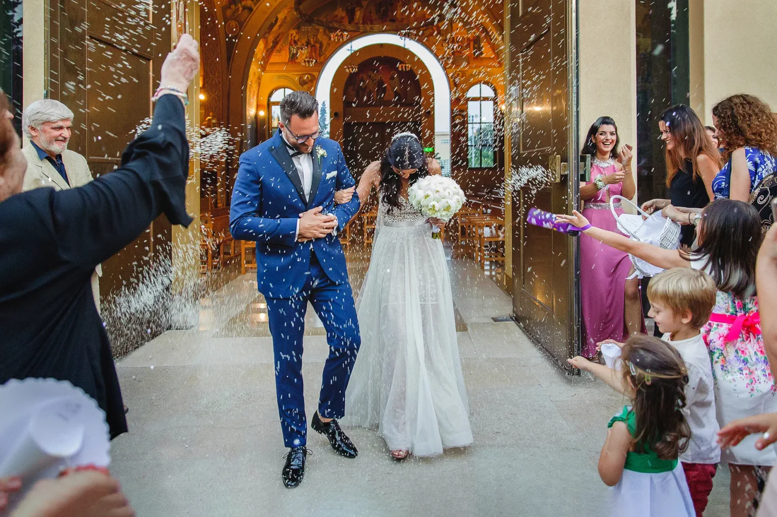 a man and woman walking down a aisle with confetti